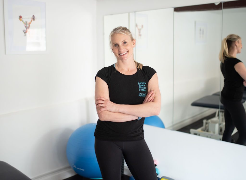 Caroline, the Pilates instructor and chartered physiotherapist, in her studio with an exercise ball behind her