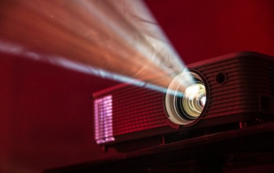 A digital projector beaming light across a darkened room